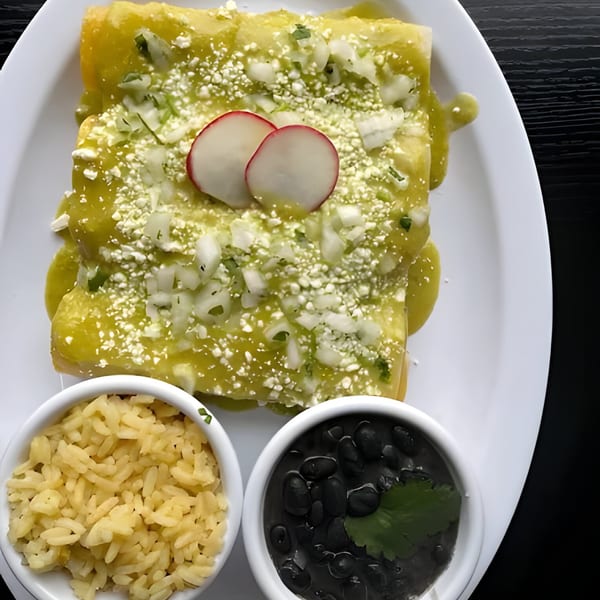 Green enchiladas topped with cheese, onions, and radishes, served with rice and black beans.