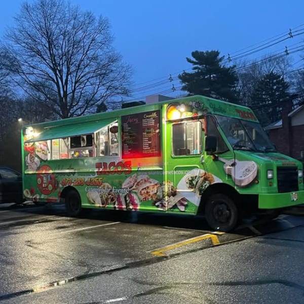 Silantro Lime Tacos food truck, bright green with taco graphics, parked at dusk.
